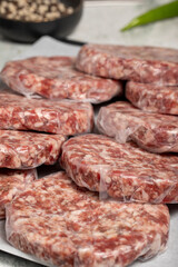 Raw hamburger Patty. Butcher products. Raw hamburger patties with gelatin on a stone background