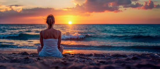 jeune femme assise de dos sur la plage en train de regarder le coucher de soleil - obrazy, fototapety, plakaty