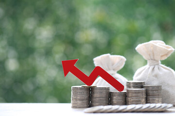 Funding,Red arrow on stack of coins money and money bag on natural green background, investment...