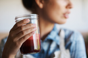 Glass, hand and smoothie with woman in kitchen of home closeup for diet, health or nutrition....