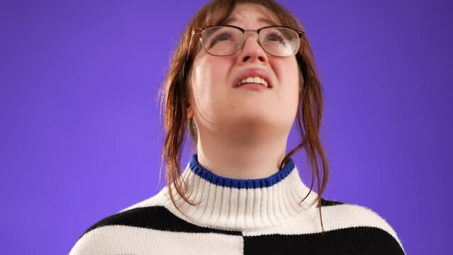 Closeup portrait of angry, scared young woman 20s put hands on head screaming crying ask why me, isolated on purple background studio. People lifestyle concept.