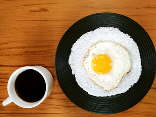 Typical Brazilian snack known as tapioca with fried egg and mug of coffee on the wooden background