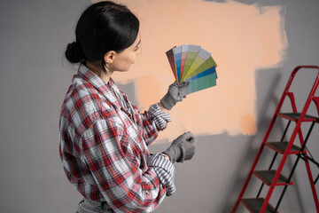 Painter or decorator with handful of colorful paint swatches