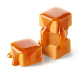 Stack of sweet caramel candy cubes topped with caramel sauce on white background - 753677725