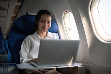 A successful and professional Asian businesswoman uses a laptop computer to plan meeting...