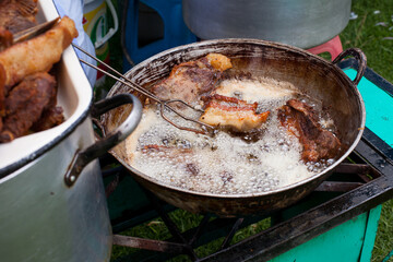 Photograph of pork frying in hot oil to prepare Peruvian chicharron. Peruvian food concept.