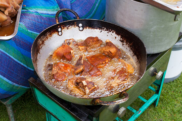 Photograph of pork frying in hot oil to prepare Peruvian chicharron. Peruvian food concept.
