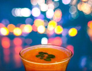 Orange Juice in Bar Glass in front of blurry blinking lights background