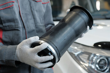 A new pneumatic cylinder is in the hands of an auto mechanic.Monitoring the integrity of the...