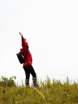 Explorando el invierno Chica con mochila y chompa rojo disfrutando del paisaje campestre bajo un cielo nublado,turista viajero,estilo de vida