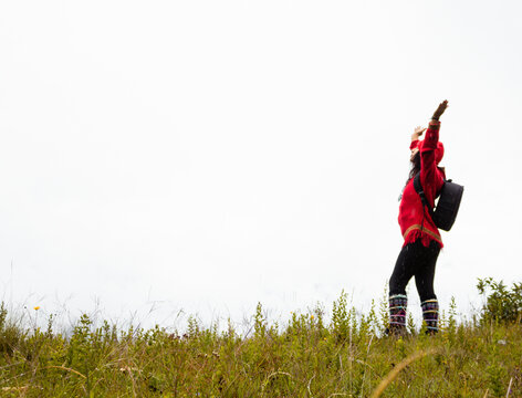 Explorando el invierno Chica con mochila y chompa rojo disfrutando del paisaje campestre bajo un cielo nublado,turista viajero,estilo de vida