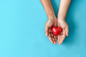 Two hands hold a red heart against a vibrant blue background, symbolizing love, care, and unity.