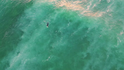 Fototapeta premium Aerial surfer swimming ocean summer weekend. Top shot surfboarder lying wave