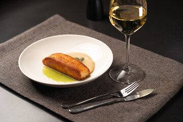 Fried salmon with different sauces and white wine served on a plate in a restaurant