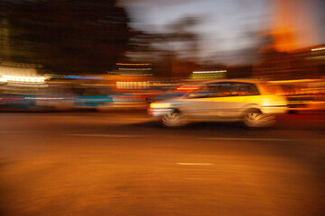 A blurry image of a black van with a yellow roof