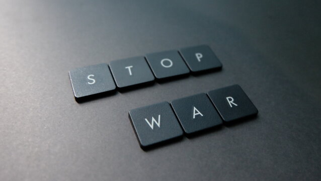Stop war word made from black plastic buttons on grey background, stop war concept