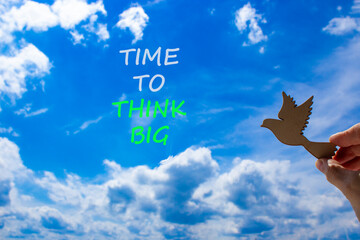 Time to think big symbol. Concept words Time to think big. Beautiful blue sky cloud background. Voter hand with wooden bird. Business and time to think big concept. Copy space.