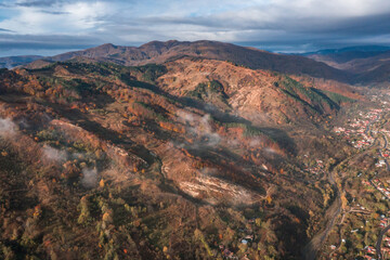 Morning view with mountain village and fog an clouds in Romania