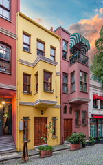 Obraz premium Facade of colorful residential buildings painted in red and yellow, at cobblestone alley suited in Kuzguncuk neighborhood, Uskudar district, Istanbul, Turkey