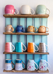 Tassen in einem Regal an der Wand aus allen Böden horizontal angeordnet