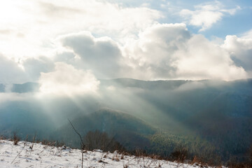 A breath of spring. The morning sun over the mountains shines through the clouds that touch the tops of the mountains
