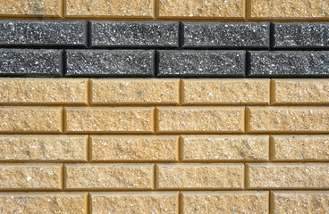 A fragment of stucco, which is made of yellow and black bricks