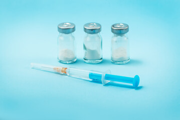 Syringe and needle with glass medical ampoule vials for injection. Medicine is dry white drug...
