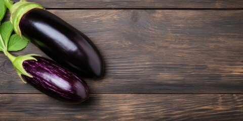 Fresh, glossy eggplant on wood table, flat lay with room for text.