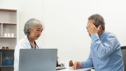 Obraz premium A senior female doctor gives advice to an elderly man at a health checkup meeting in the hospital. Specialist GPs provide medical advice to adult patients.