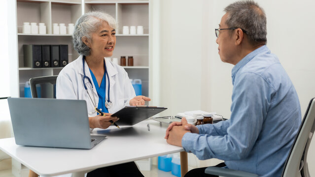 A senior female doctor gives advice to an elderly man at a health checkup meeting in the hospital. Specialist GPs provide medical advice to adult patients.