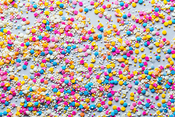 Obraz premium Assorted Colorful Sprinkles on White Background with Blue, Yellow, Pink and White Color Scheme