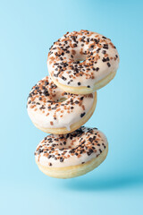 Fresh donuts on blue background. Minimal food concept.
