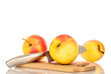 Three yellow apples and a knife on a wooden kitchen board, macro, isolated on white background