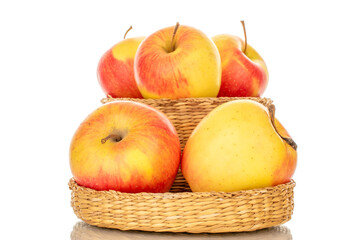 Several yellow apples in a straw basket, macro, isolated on a white background