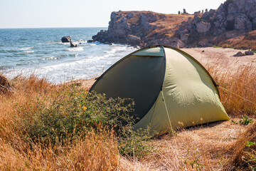 Tourist tent on the seashore with a beautiful rocky shore. Travel and tourism