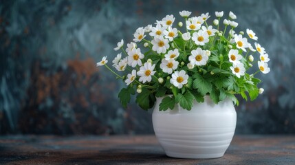 a white vase filled with white flowers sitting on top of a wooden table next to a green leafy plant.