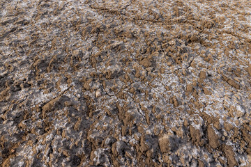 cracks and fractures on the frozen soil of the field in winter