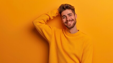 Positive glad Young handsome Caucasian man wearing yellow sweater against orange wall says: wow how exciting it is, indicates something. One hand on his head and pointing with other hand