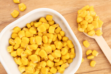 Sweet corn kernels in bowl on wooden table still life