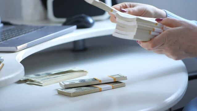 close-up of female hands counting a stack of hundred-dollar US banknotes. a businesswoman is counting cash. the concept of investment, money exchange, bribes or corruption. 4K