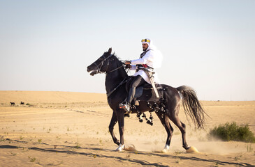 Rider in the desert of Saudi Arabia with his back stallion
