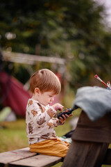 Toddler in Animal Print Shirt Talking on Toy Phone Outdoors