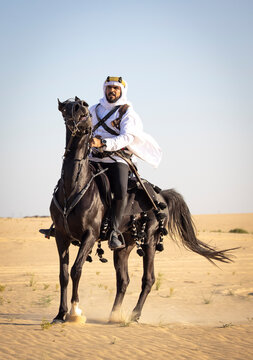 Rider in the desert of Saudi Arabia with his back stallion