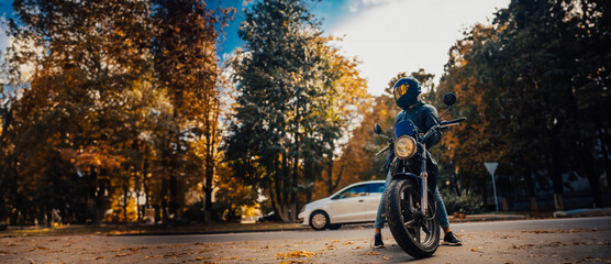 stylish male motorcyclist in a leather jacket and jeans with a classic city motorcycle