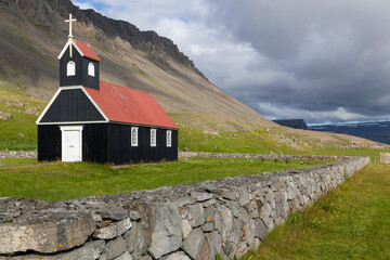 the famous Saurbæjarkirkja wooden, church at the Rauðisandur Beach in iceland.