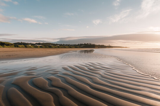 Serene sunset over ripple patterned sand at a secluded coastal beach