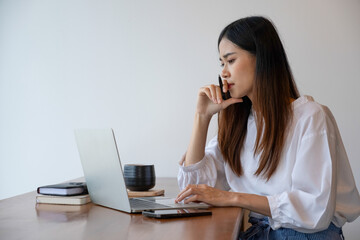 Young woman engages in online study or work at cafe.