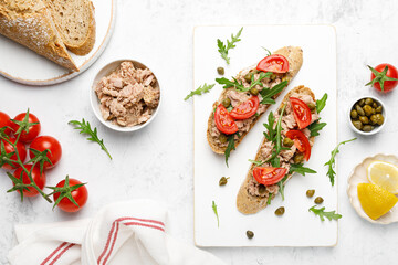 Tuna caper toasts with arugula, tomatoes and whole rye bread, top view