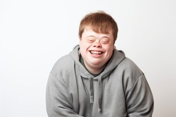 Young man with Down Syndrome smiling at the camera on white background