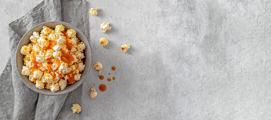 Obraz na płótnie Canvas popcorn. top view of popcorn with caramel sauce on grey bowl, copy space